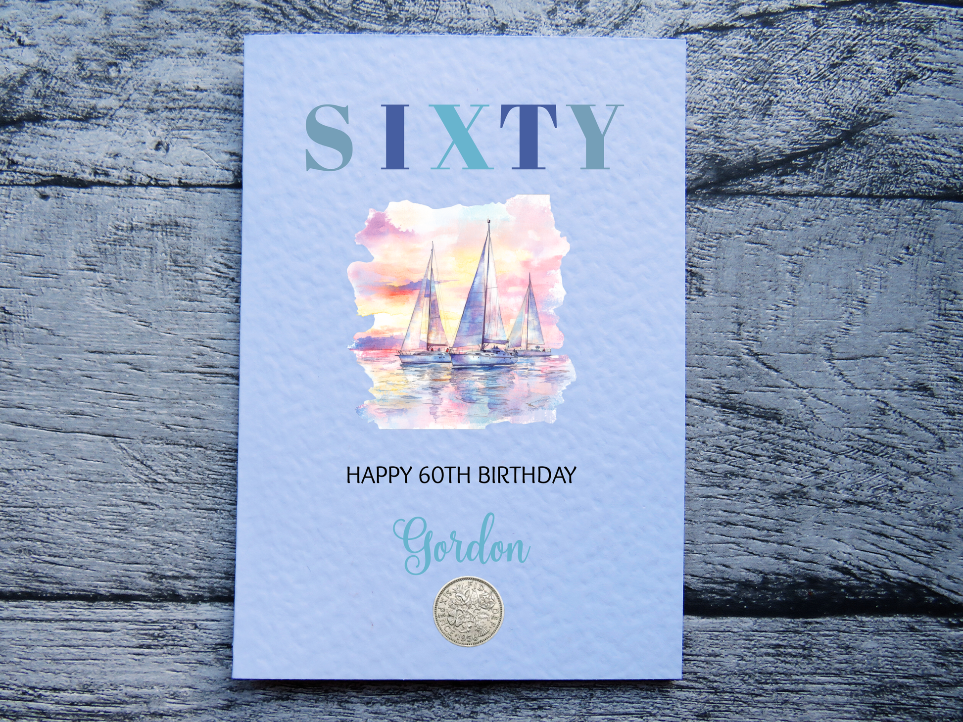 Sailing themed 60th birthday card with real 1966 sixpence, personalised with a name on a wooden surface