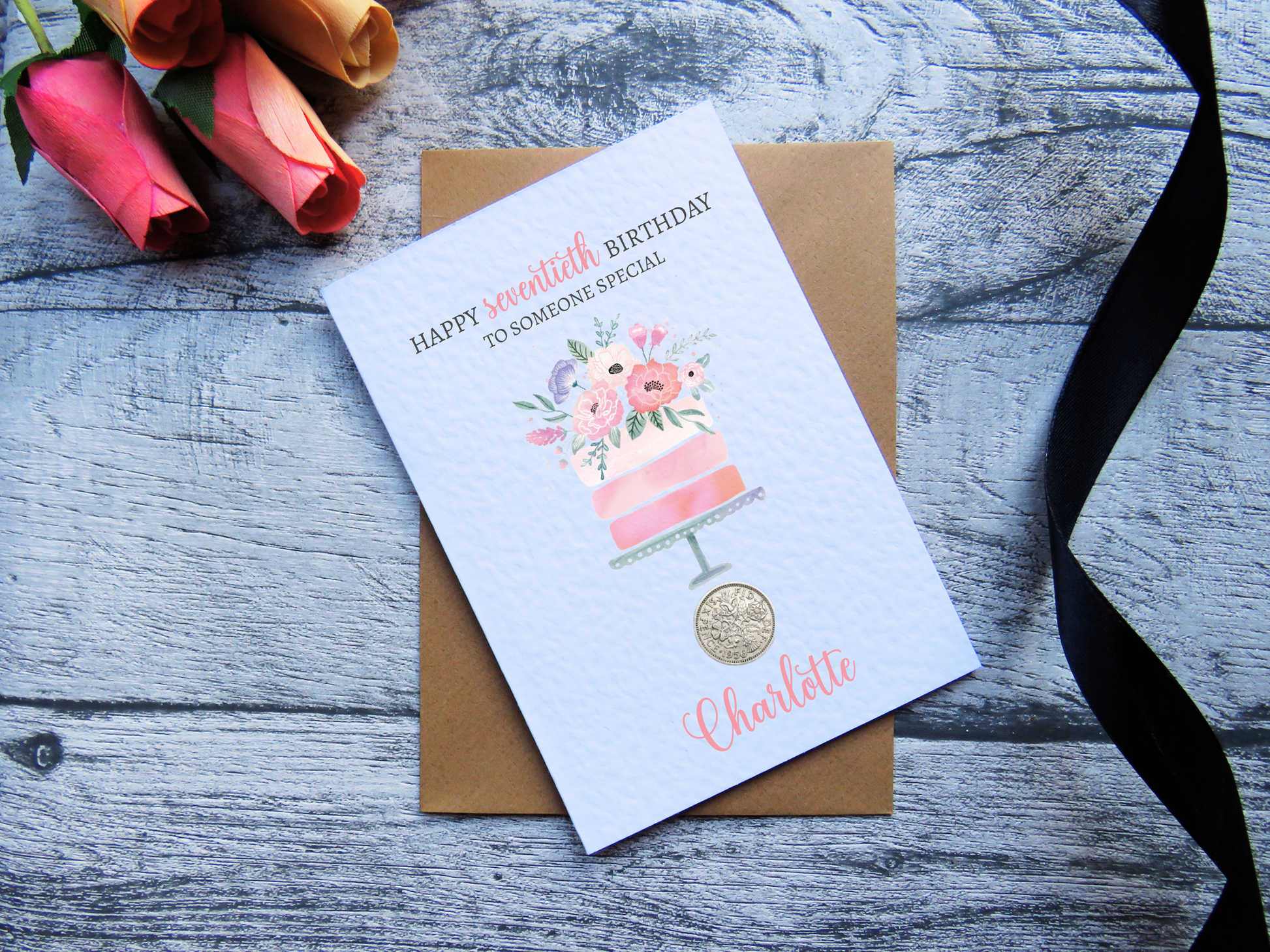 Cake 70th Birthday Card with Genuine 1956 Coin on wooden surface with black ribbon