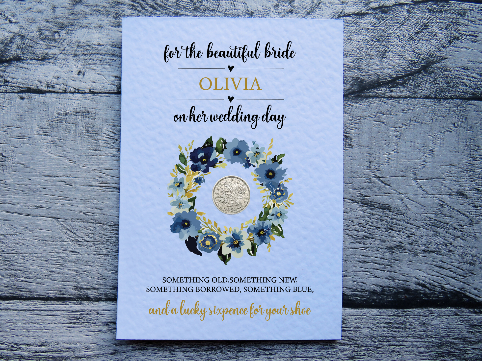 Personalised bride wedding card with blue floral wreath and real lucky sixpence on wooden surface